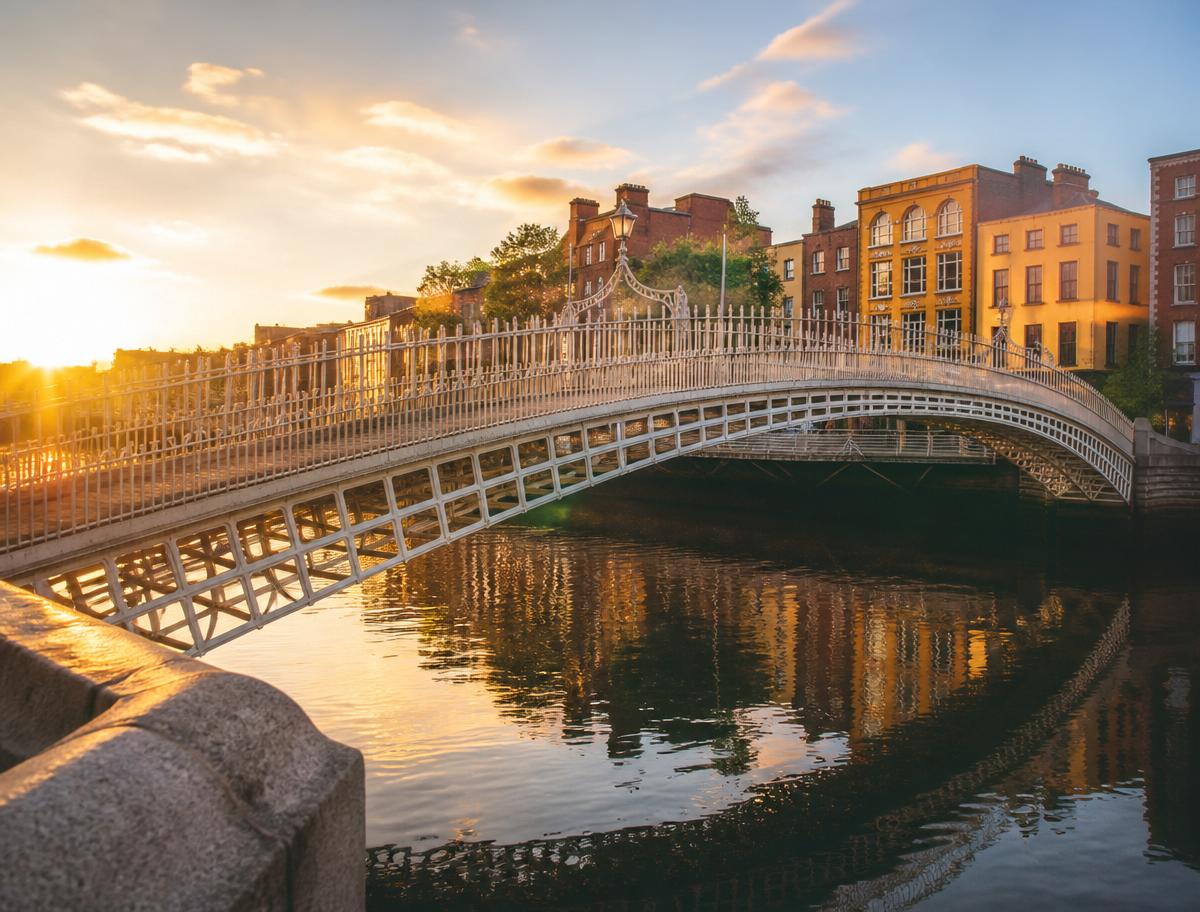 Ha'penny Bridge sobre o Rio Liffey em Dublin ao pôr do sol, Irlanda